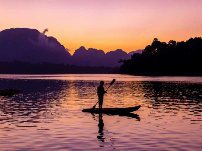 800 - Khao Sok - man-stand-paddling-on-his-kayak-at-ratchaprapa-dam-or-known-as-cheow-lan-dam-during-sunrise