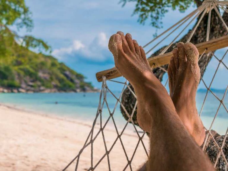 800 - Koh Phangan - men-feet-in-hammock-relaxing-on-the-beach-in-haad-rin-ko-phangan-thailand